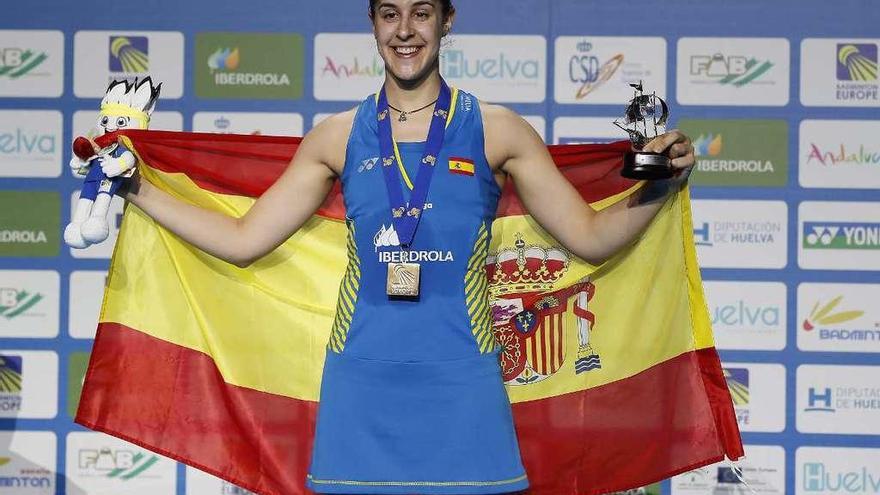 Carolina Marín posa con la medalla de oro y la bandera española en lo más alto del podio.