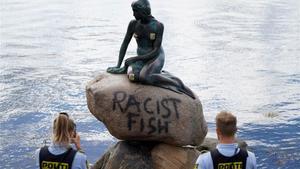 La policia saca fotos de la pintada que reza  ’Pez Racista’ en la base de La Sirenita, en Copenhague.