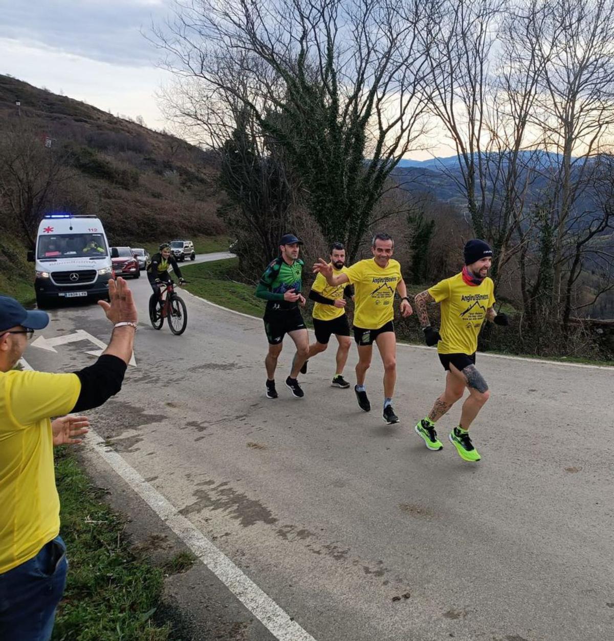 Héctor Moro, con varios acompañantes, remontando el Angliru.