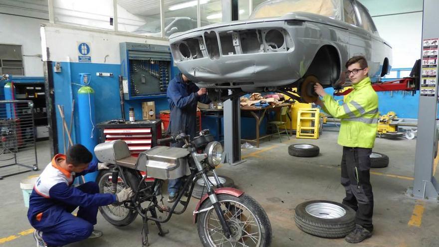 Trabajando en la moto, Abdelhadi Movaddine, y en el coche, Fouad Baynya y Pedro Losas.