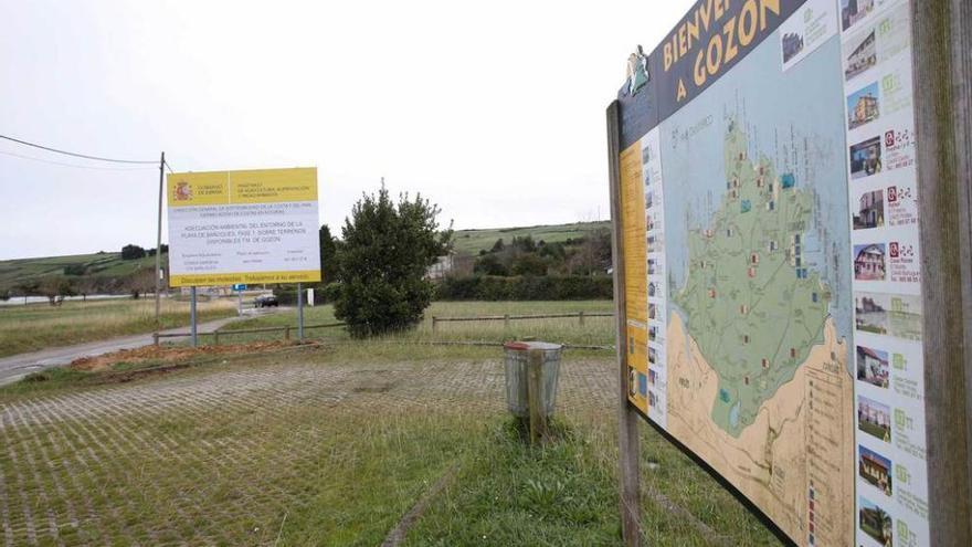 El cartel que anuncia las obras de Bañugues, ayer, en el entorno del aparcamiento de la playa.