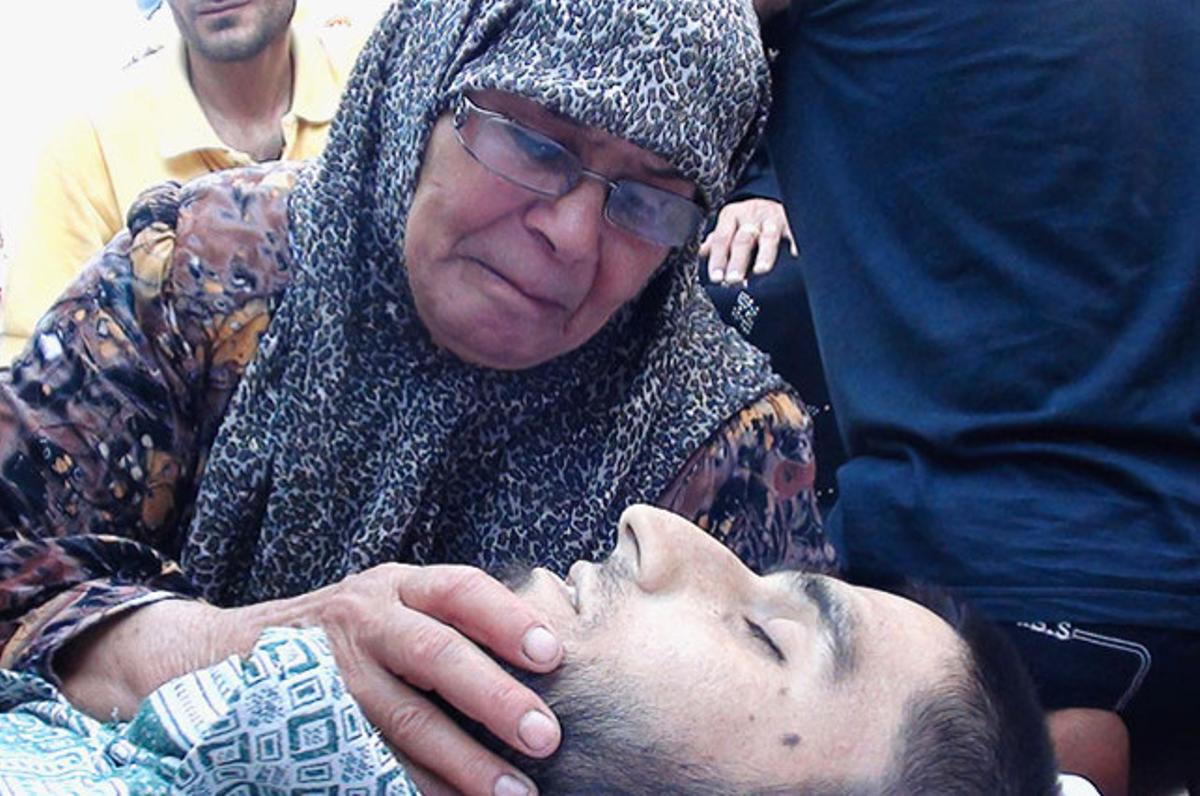 Un familiar plora davant del cos sense vida de Iamen Qassam, suposadament assassinat per les forces fidels al president Baixar al-Assad, durant el seu funeral a Idlib (Síria).