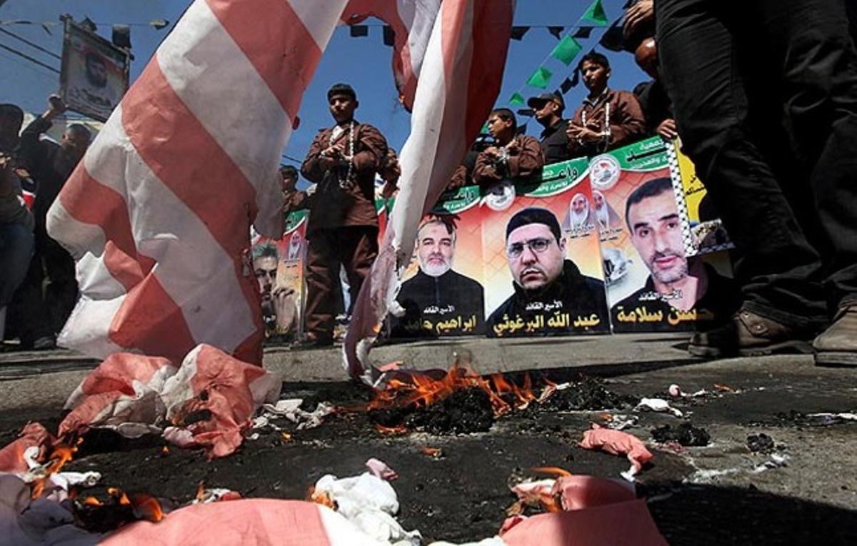 Un grup de palestins cremen una bandera dels Estats Units durant una protesta per mostrar la seva solidaritat amb els presos empresonats a Israel, a la ciutat cisjordana d’Hebron.
