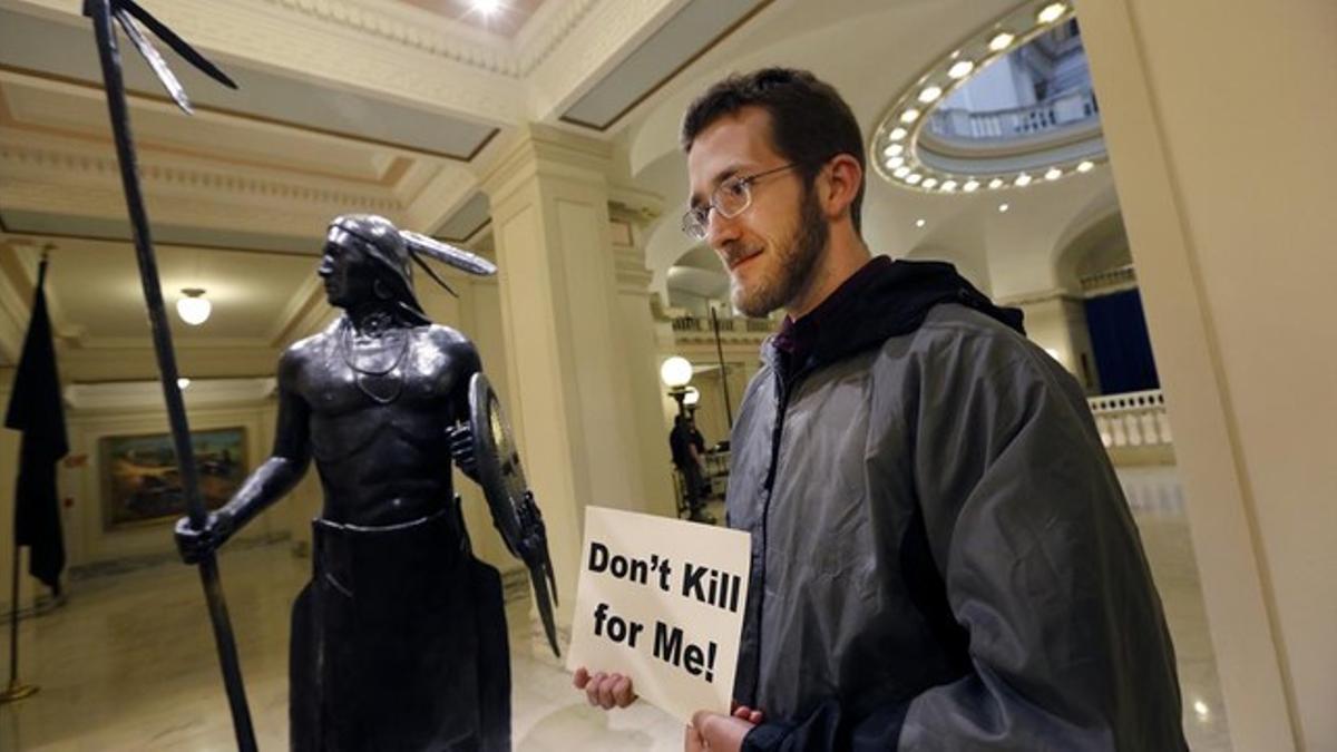 Sam Jennings, de la Coalición de Oklahoma contra la pena de muerte, sostiene un cartel en contra de la pena capital en el Parlamento estatal de Oklahoma, el 29 de abril.
