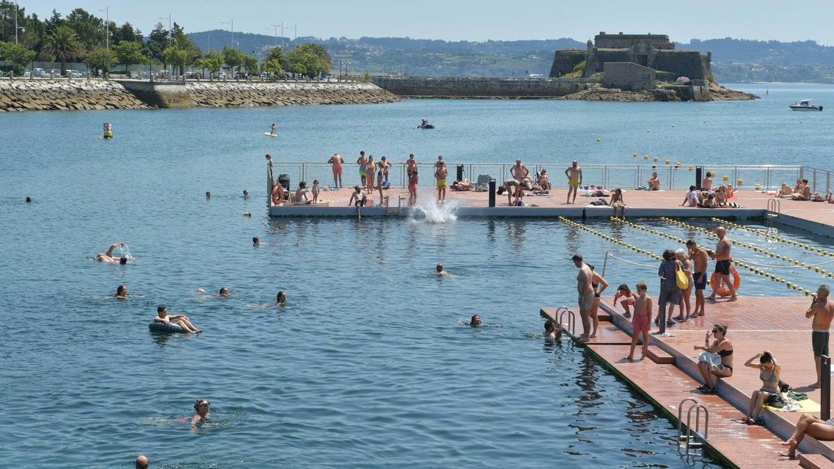 Gente disfrutando del baño en la plataforma de O Parrote este domingo