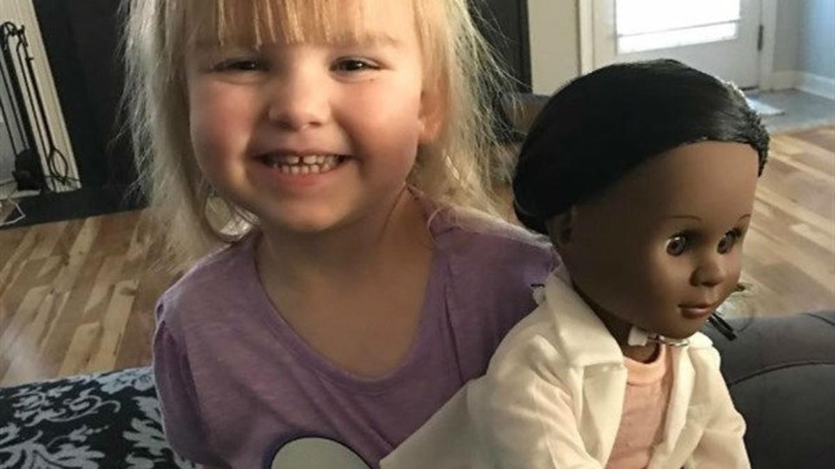 La pequeña Sophia, de 2 años, con su muñeca negra.