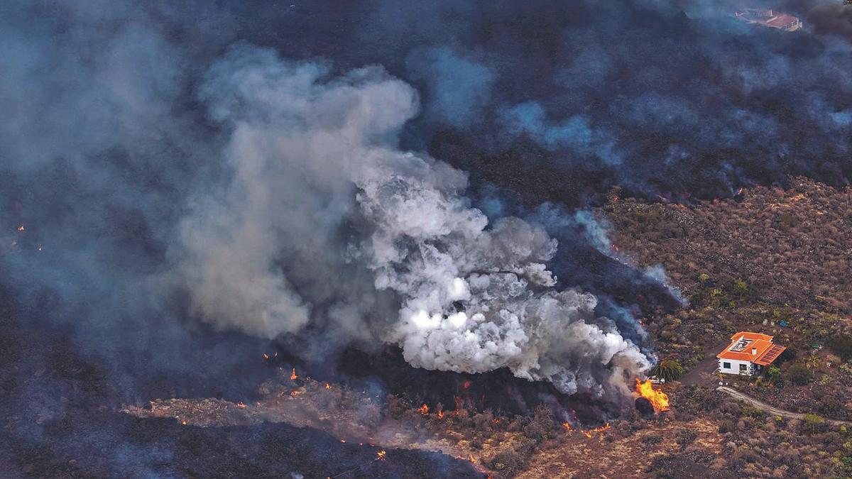 Imagen tomada desde un helicóptero de una casa rodeada de lava en Los Llanos de Aridane, en La Palma.   | // LOVETHEWORLD