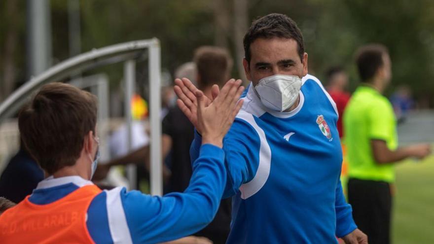 Miguel Losada felicita a un jugador tras una sustitución.