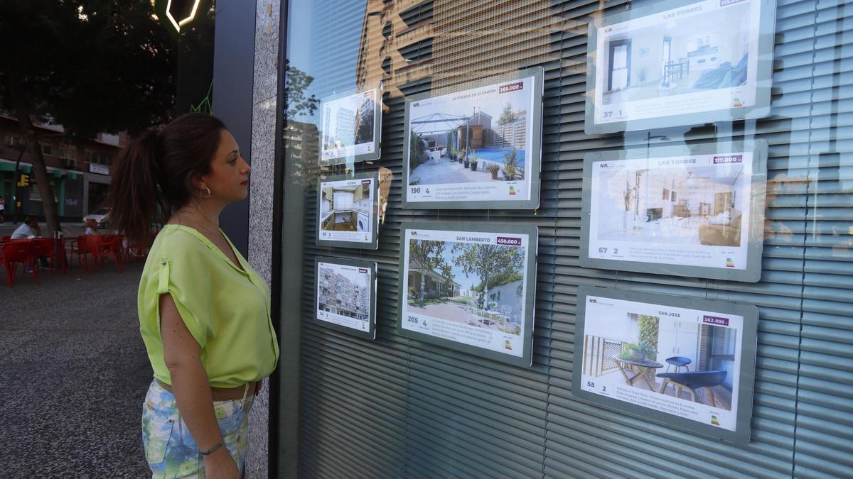 Una joven mirando carteles de venta o alquier de pisos