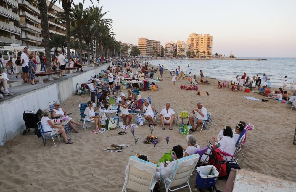 Noche de hogueras, baños, en las playas de la Vega Baja. En las imágenes grupos de amigos y familias en la playa del Cura de Torrevieja