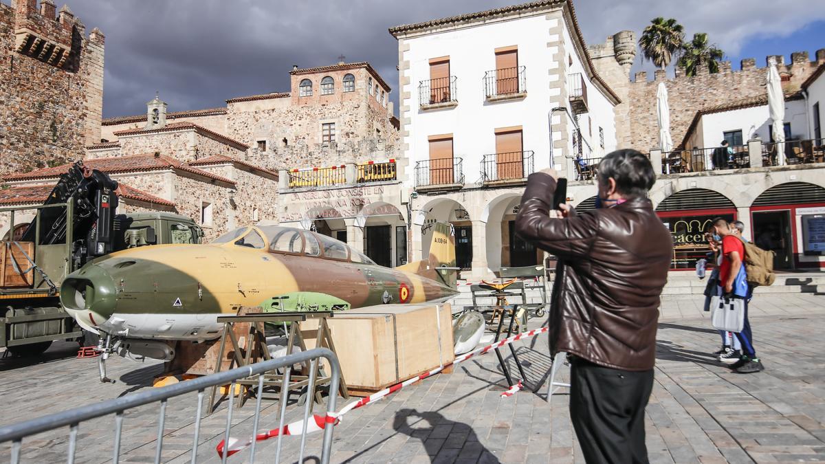 Un cacereño fotografía a uno de los aviones militares, durante su montaje este lunes en la plaza Mayor.