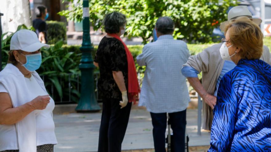 Varias personas conversan en la calle.