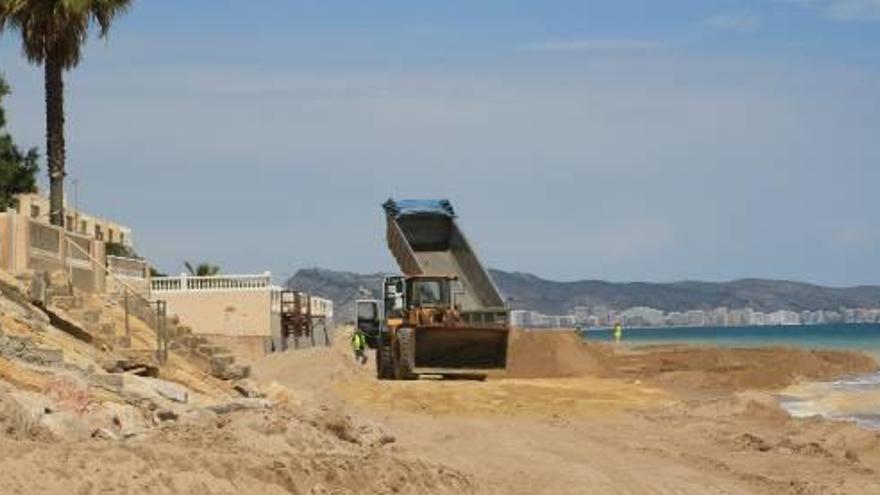 Un camión vierte arena en la zona próxima a las edificaciones de primera línea de la playa de la Goleta.