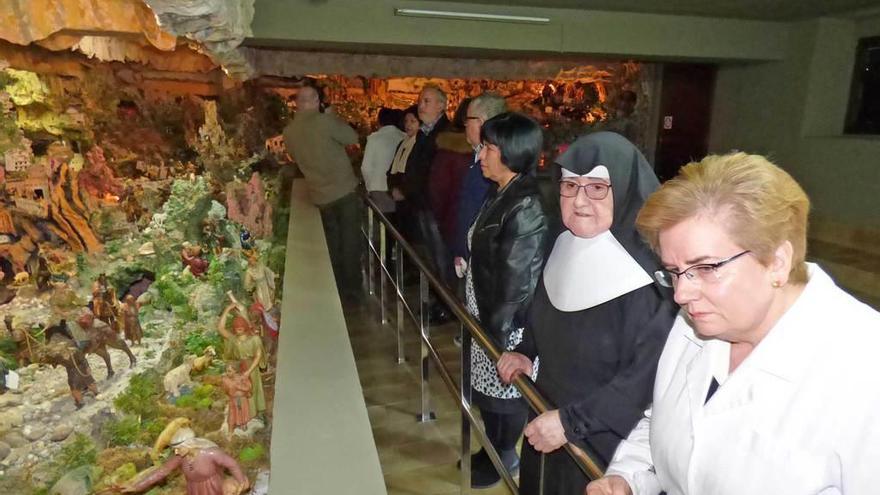 A la izquierda, Sor Asunción González y Ana María García enseñan el belén. A la derecha, arriba, María Rodríguez y su prima Carmen Justel, y abajo, un detalle de Jerusalén, donde se divisan el templo, el palacio de Herodes, el Huerto de los Olivos y el Gólgota con las tres cruces en lo alto.