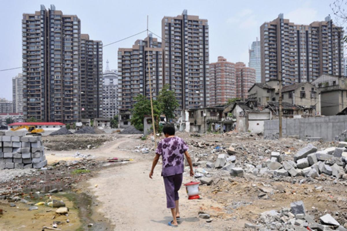 Una dona camina en un terreny arrasat per l’especulació immobiliària a Xangai (Xina)