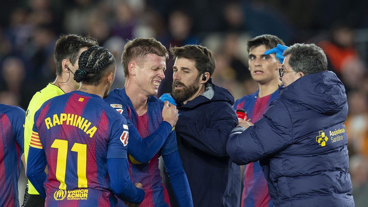 Olmo atendido por los médicos tras anotar el segundo gol y lesionarse en la caída durante el partido de liga entre el FC Barcelona y el Atlético de Madrid en el Spotify Camp Nou