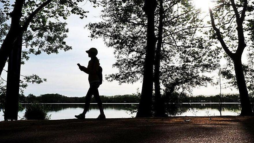 Una persona passeja pel costat de l&#039;estany de Banyoles