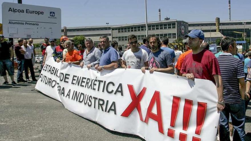 Un grupo de trabajadores de Alcoa protesta ante la puerta de la factoría, en A Grela.