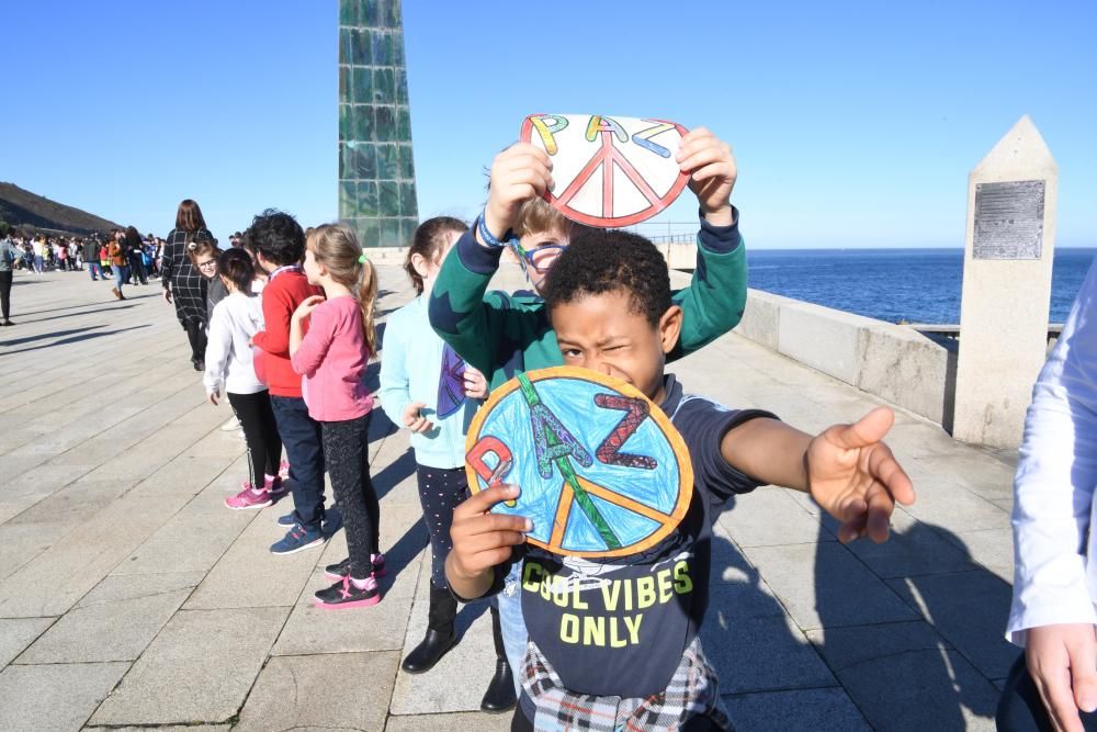 Escolares de A Coruña conmemoran el Día de la Paz con una cadena humana que recorrió el paseo marítimo hasta la Torre de Hércules y la lectura de un manifiesto.