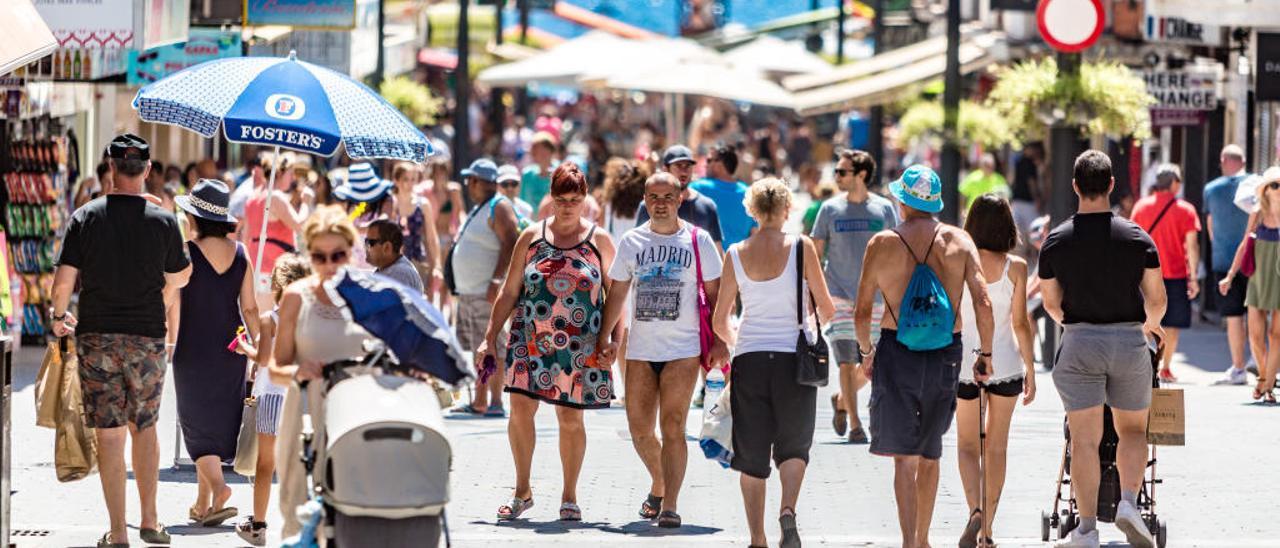 Un grupo de personas paseando por la calle Martínez Alejos, situada en pleno centro urbano de Benidorm.