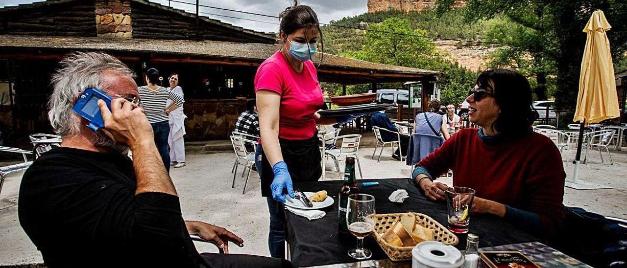 Una trabajadora del chiringuito los Arenales atiende a Marc Inglés y Patricia Berenguer, ayer.