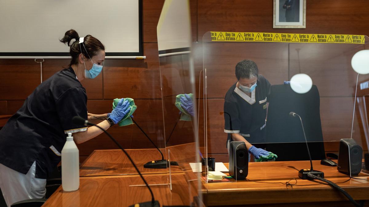 Las trabajadoras de limpieza Rocío Matilla y Laura Hernández trabajan en una sala de vistas de los juzgados.