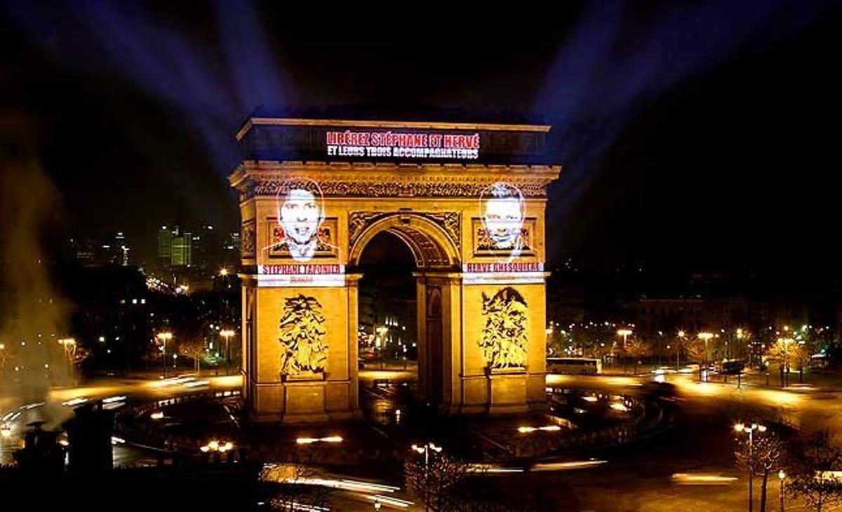 Les cares dels periodistes Herve Ghesquiere i Stephane Taponier, del canal de televisió France 3, projectats a l’Arc del Triomf a París per commemorar el primer aniversari del seu captiveri en mans dels talibans a l’Afganistan.