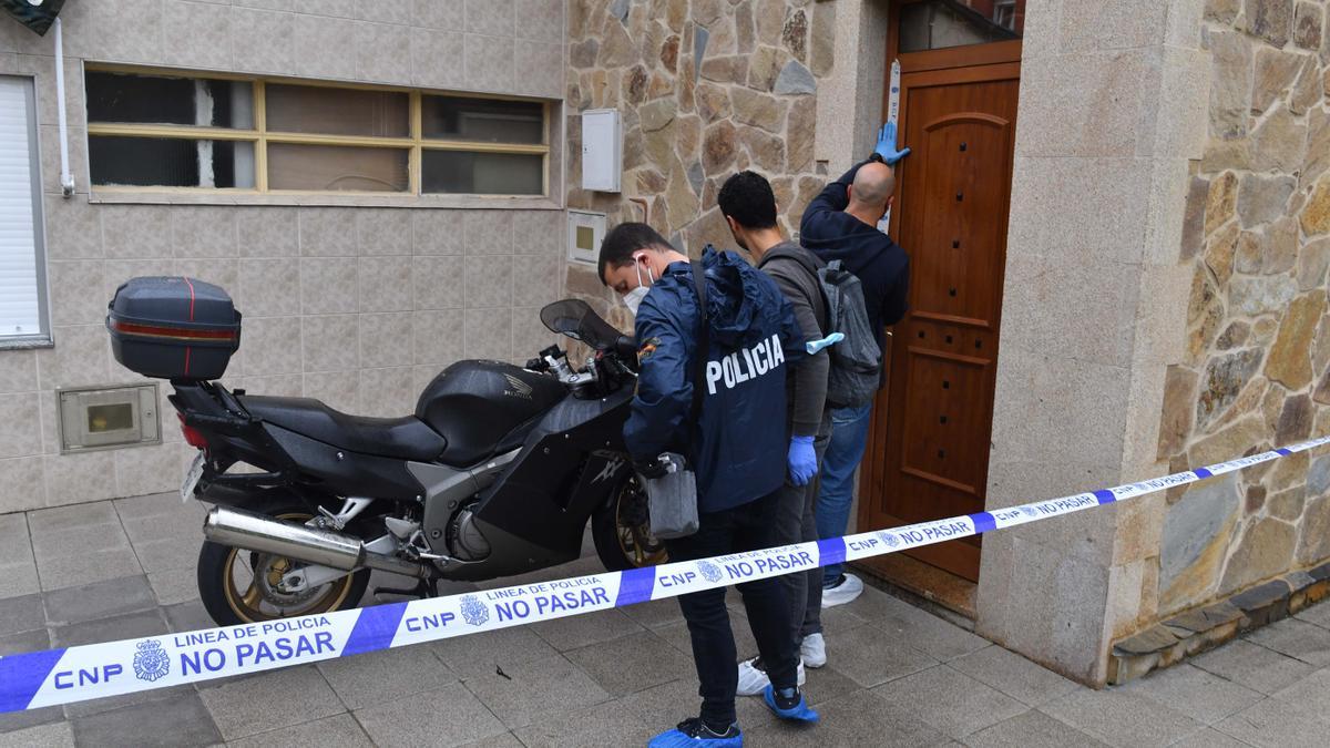 Agentes de la policía científica, tras inspeccionar la vivienda donde fue encontrado muerto a puñaladas un hombre en el Barrio de las Flores, en A Coruña.