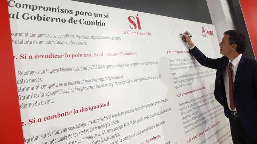 Pedro Sánchez firma el documento con sus compromisos electorales. // Efe