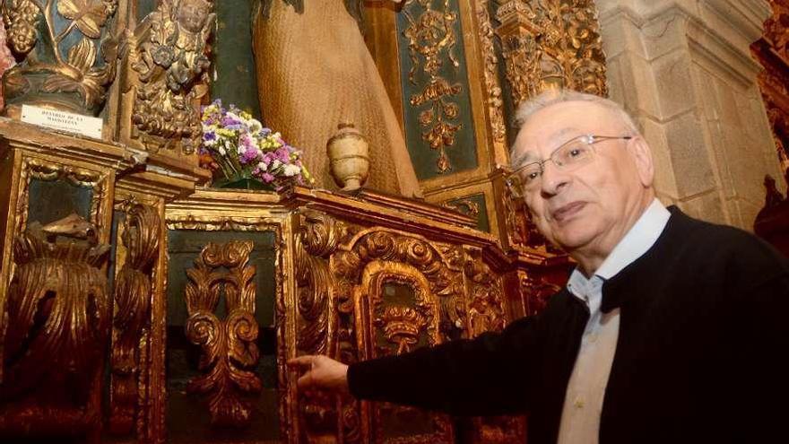 El párroco, Raúl Lage, ante el retablo afectado. // Rafa Vázquez