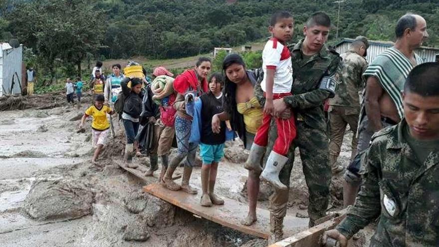 Soldados del Ejército ayudan a evacuar a un grupo de víctimas.