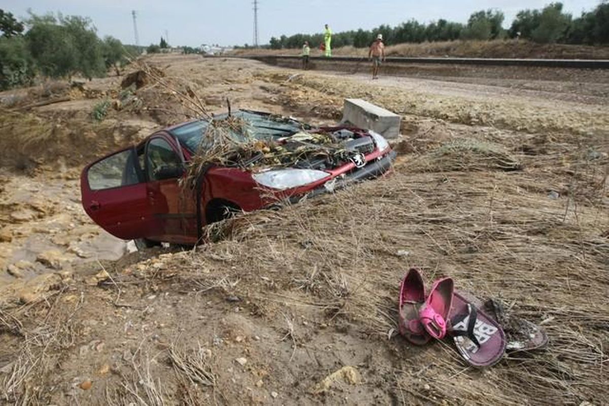 Un cotxe encallat al fang després de ser arrossegat per la riuada a la carretera A-340.