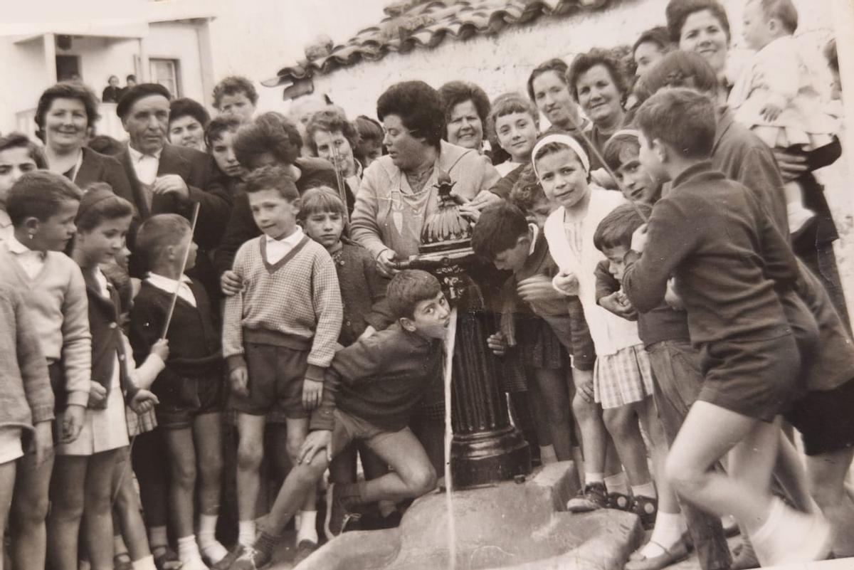 Avelino Cadavieco bebiendo de niño de la bomba de agua que había en el centro del pueblo, a principios de los años sesenta, un día de fiesta.