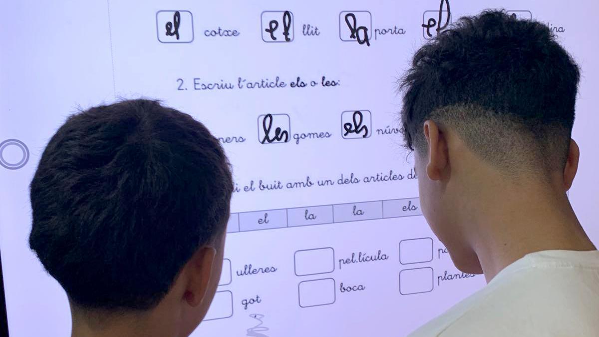 Dos alumnos realizan unos ejercicios en valenciano.