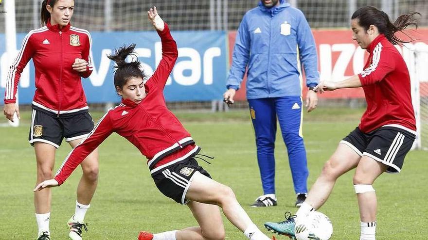 Lucía García, a la izquierda, disputa el balón en un entrenamiento en Las Rozas de la sub-20, con el seleccionador, Pedro López, al fondo.