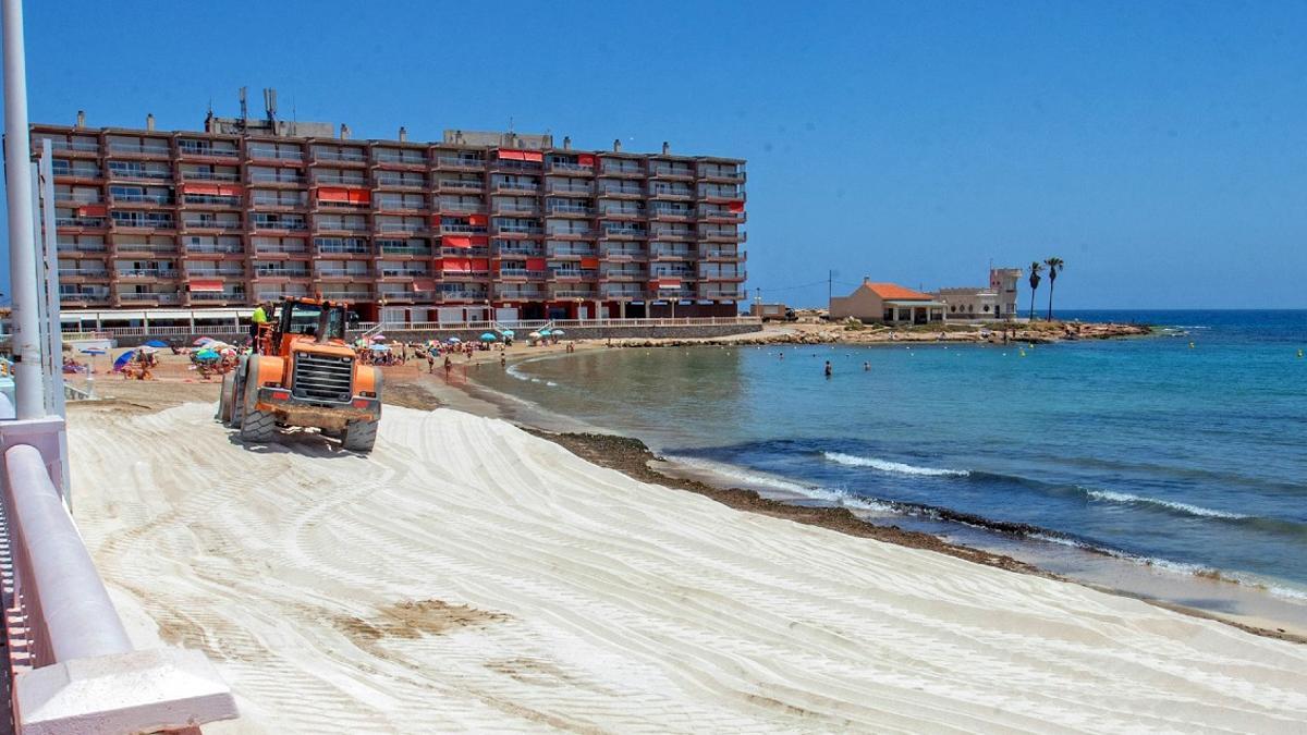 Playa de los Locos durante los trabajos de reposición de arena. Al fondo, el edificio de Luz-Mar y los chalés situados en dominio público marítimo terrestre con concesión de Costas