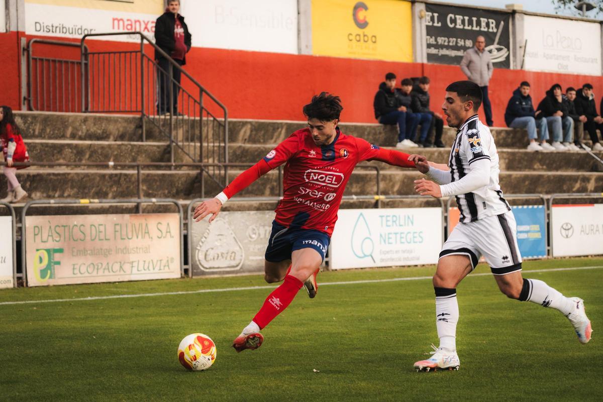 Álex Alcira persigue a un futbolista del Olot en el partido de este domingo.