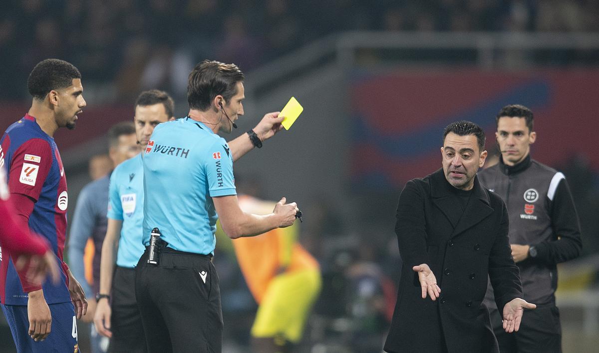 Xavi amonestado por el árbitro Munuera Montero con tarjeta amarilla durante el partido de liga entre el FC Barcelona y el Villarreal.