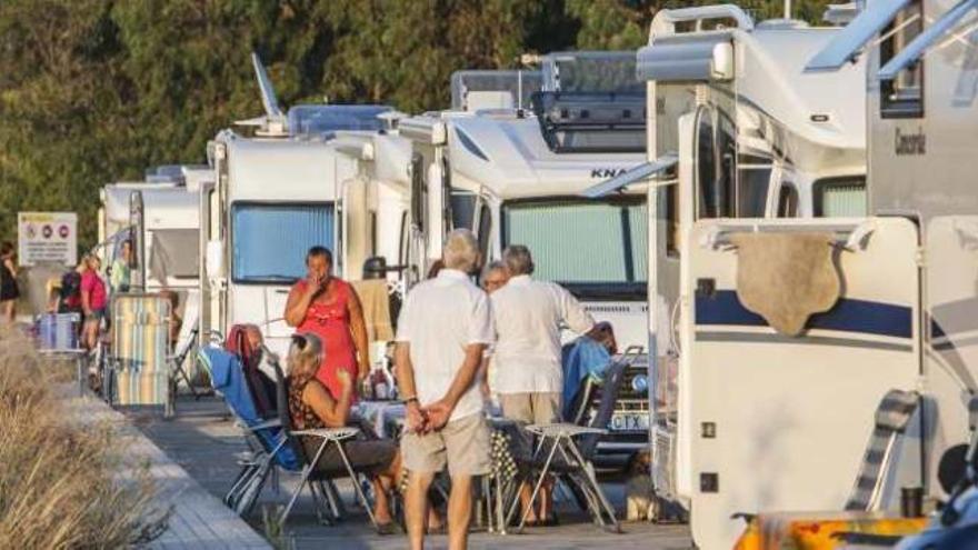 Un grupo de extranjeros disfrutan de la tarde a la puerta de sus caravanas.