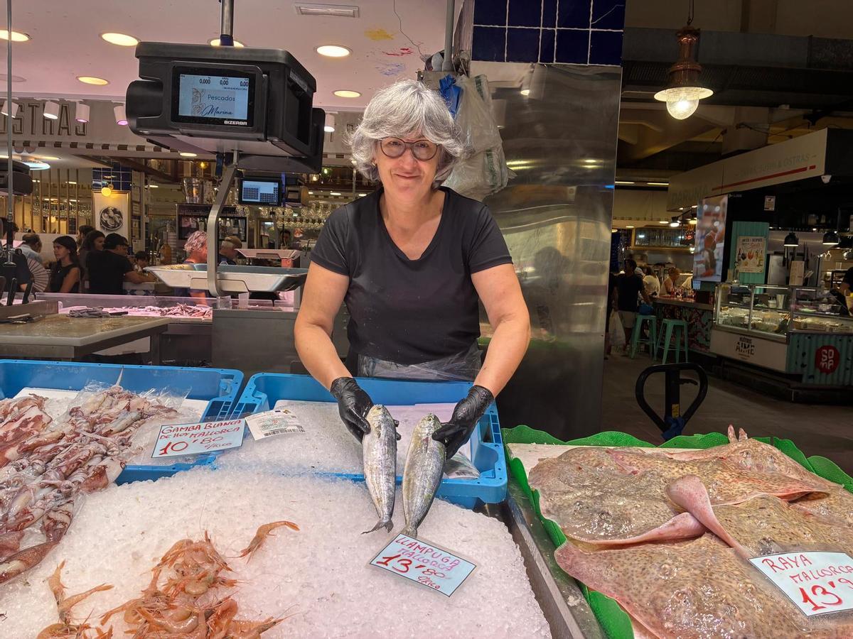 Cristina Calvo, de Pescados Marina, sosteniendo dos llampugas.