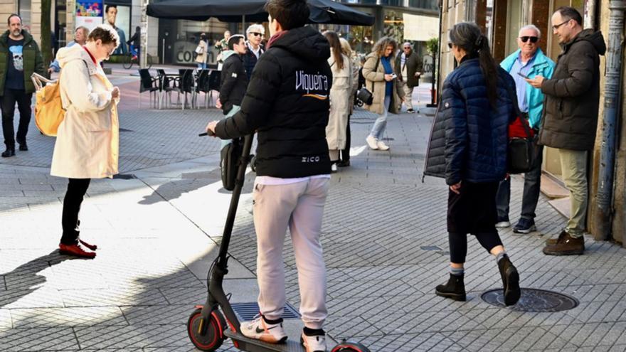Un usuario de un patinete eléctrico circulando por el centro de la ciudad.