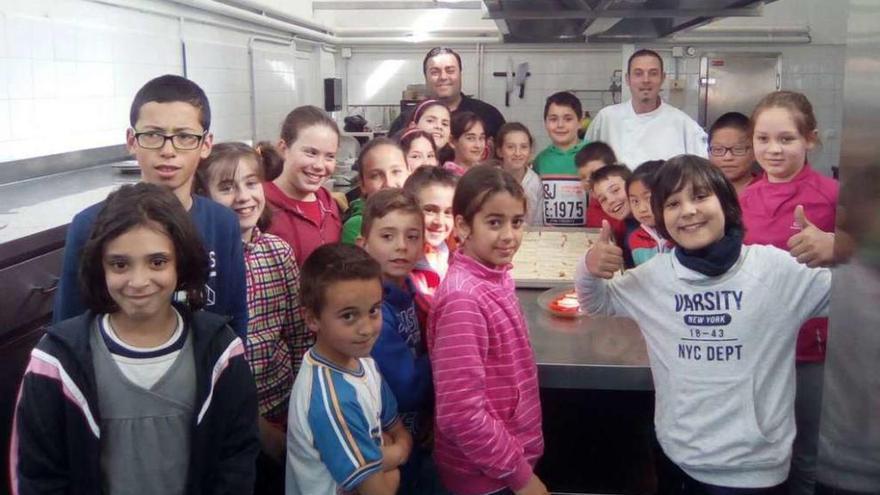 Niños de los colegios de Soutelo y Cerdedo, ayer, con García y Parada en la cocina del centro soutelano.