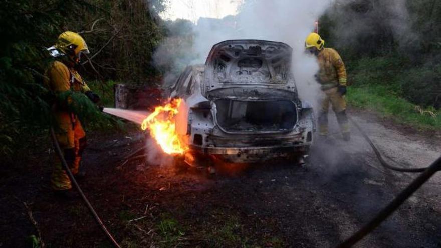 Los bomberos extinguieron las llamas del Audi A6 que apareció quemado en Meis.  // Noé Parga