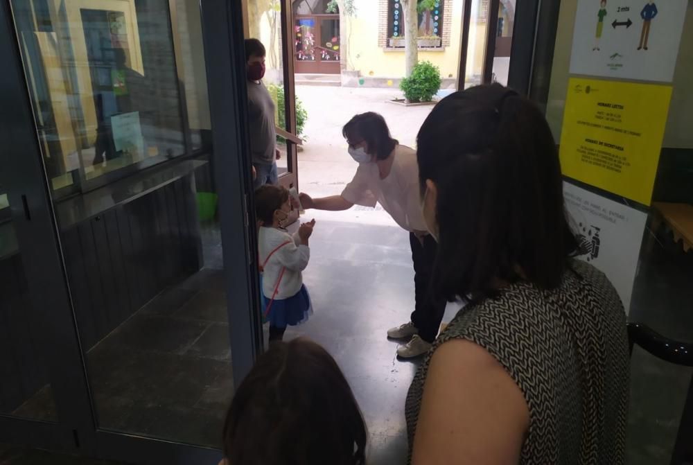 Una docent pren la temperatura a una nena a l'escola Arrels de Solsona.