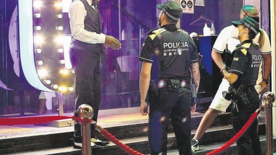 Una patrulla de la Guardia Urbana de Barcelona conversa con un trabajador de una discoteca.