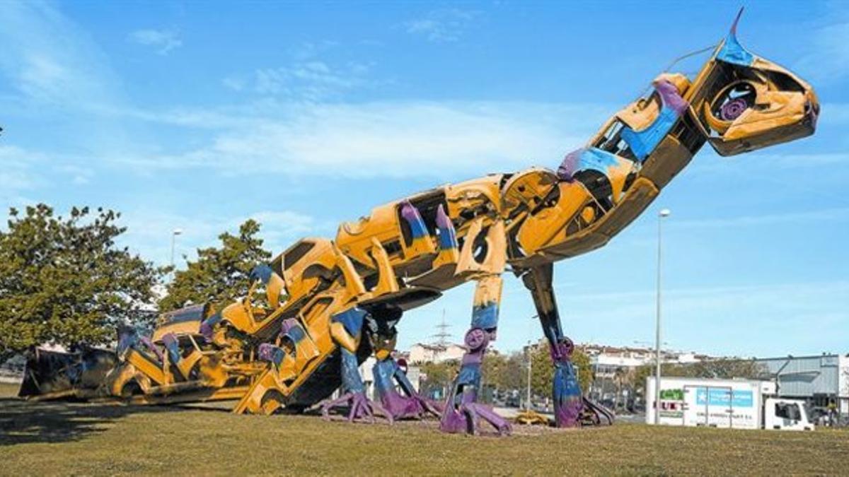 Amo y señor de la rotonda 8 'Dino', la escultura de Roc Alabern hecha con coches, en su glorieta, el viernes.