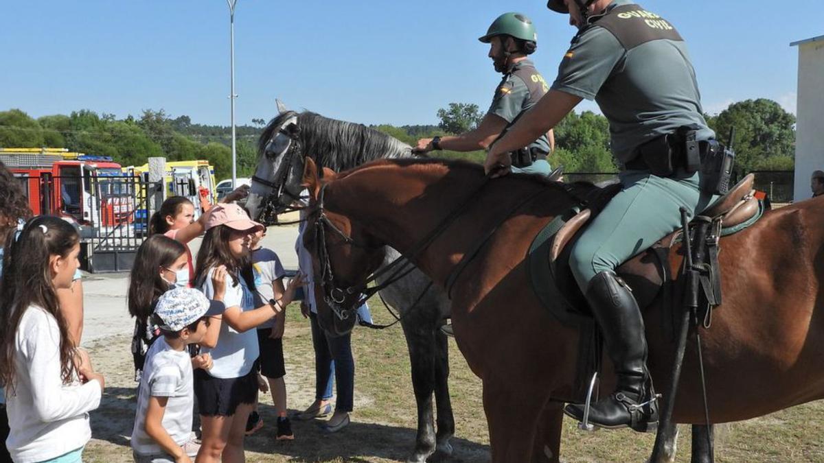 Dos guardias a caballo junto a un grupo de niños.