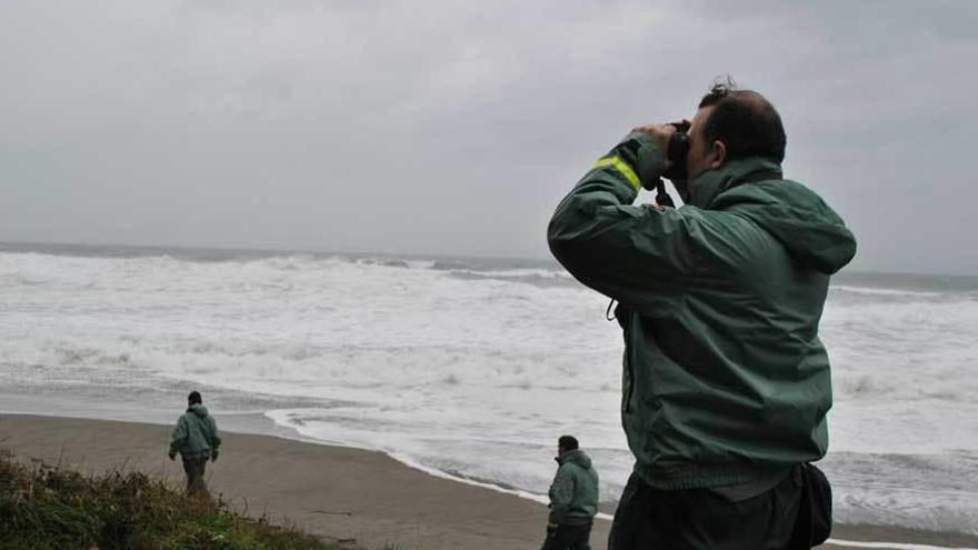 Tres agentes, rastreando la costa en busca del niño desaparecido.