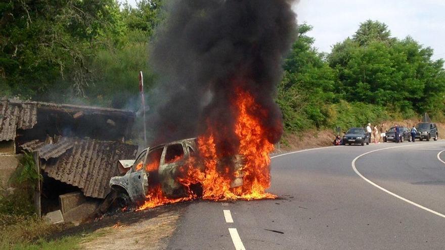 El coche ardiendo tras colisionar con un galpón.