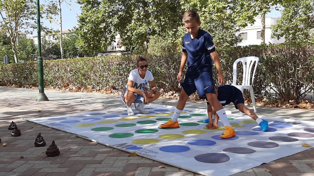 Dos niños juegan al &#039;twister del reciclaje&#039; en el parque Manuel Navarrete, en Málaga